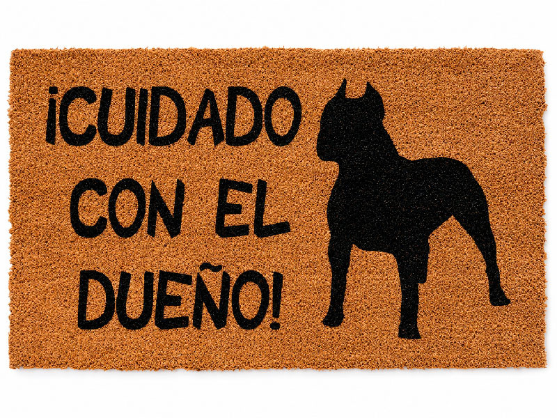 Felpudo divertido de fibra de coco con la frase Cuidado con el Dueno y la silueta en negro de un perro pitbull