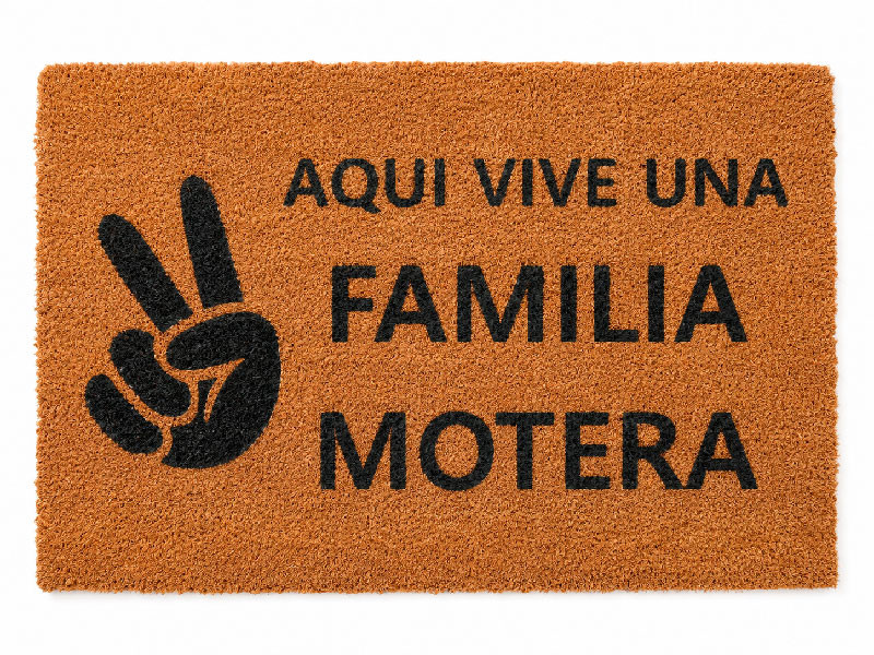 Felpudo original de fibra de coco con la frase Aqui vive una familia motera y dibujo del saludo motero con los dedos en V