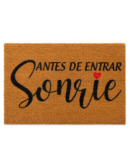 Felpudo de fibra de coco natural con la frase manuscrita Antes de entrar, sonrie decorado con un pequeño corazon rojo