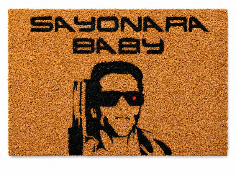 Felpudo de fibra de coco natural con el texto Sayonara Baby y el dibujo de la cara de Terminator con gafas de sol