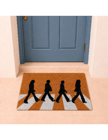 Felpudo de fibra de coco inspirado en Abbey Road con siluetas cruzando el paso de cebra colocado en la puerta de casa