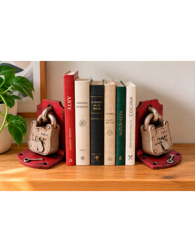 Sujetalibros con forma de candado vintage colocado junto a varios libros en una estantería.